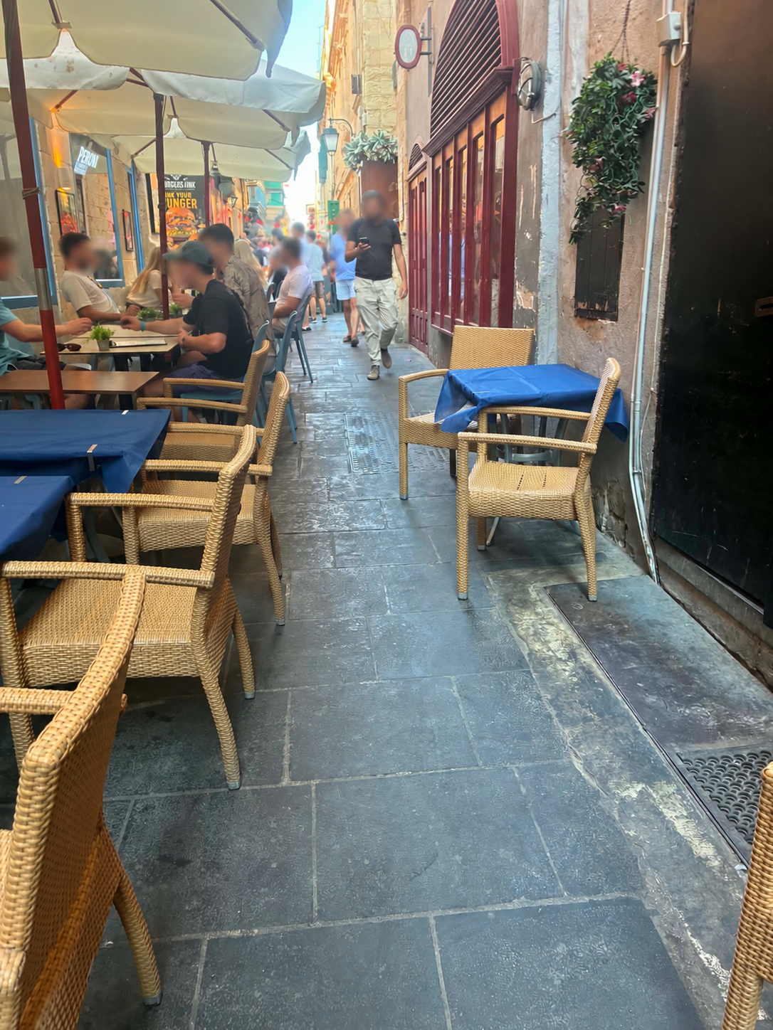Outdoor tables and chairs reducing available space in a narrow Valletta street